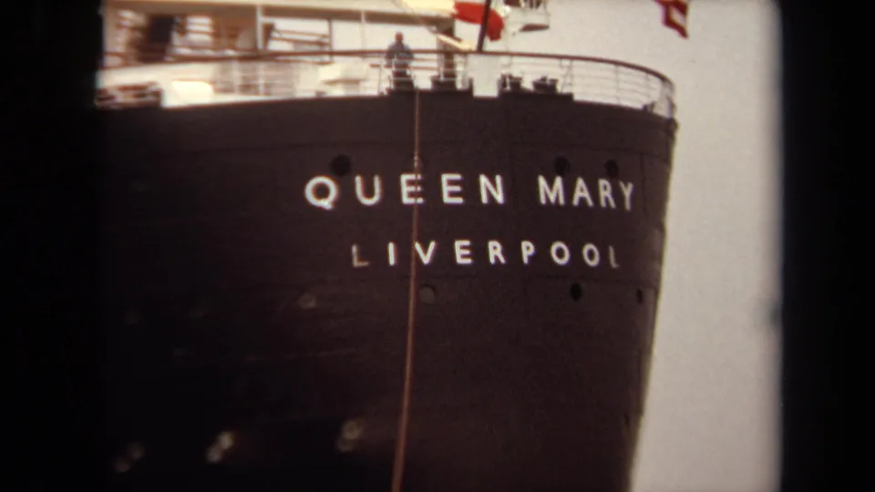 1971 Long Beach frame showing a close view of the Queen Mary stern with QUEEN MARY LIVERPOOL lettering and small people on deck.