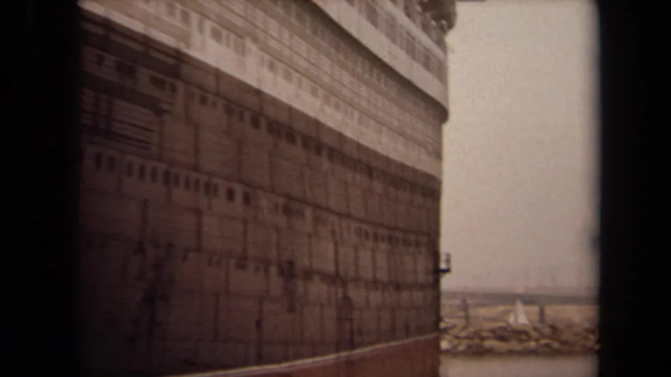1971 Long Beach frame with a large ocean liner filling the view, showing dark lower hull, white superstructure, and rows of portholes.