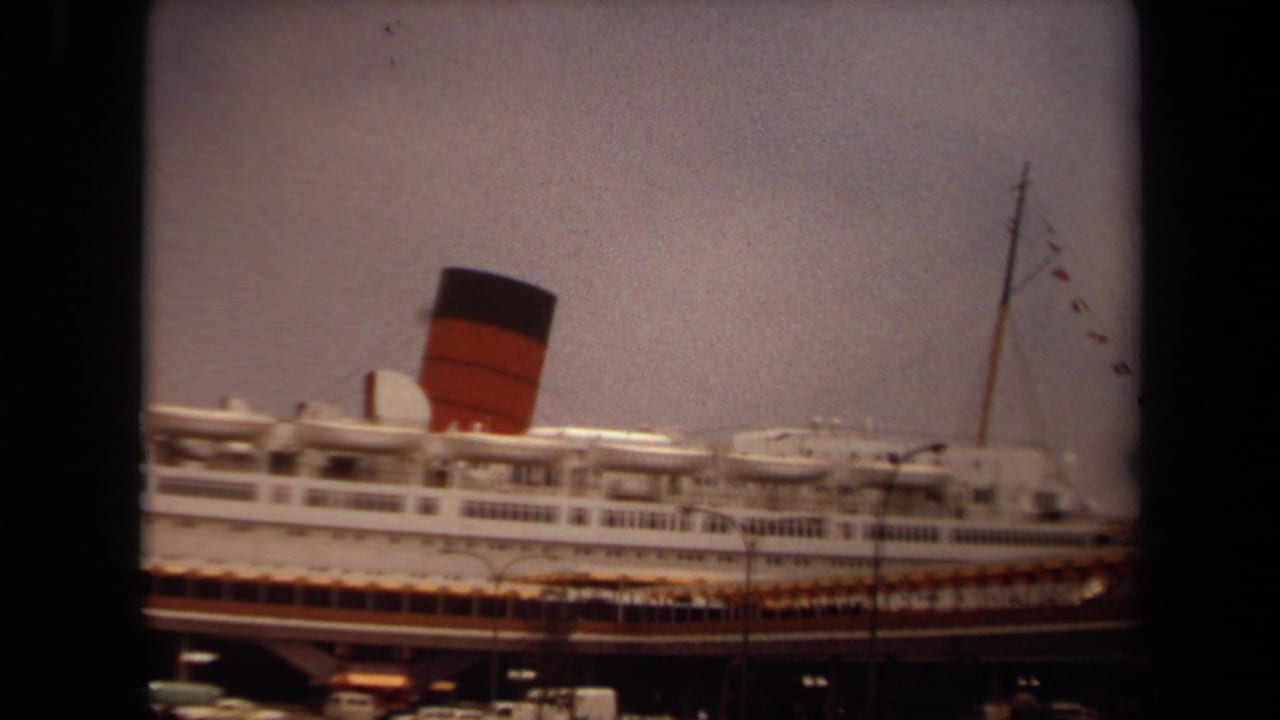 1971 Long Beach 8mm frame showing a large white ocean liner at a pier, with a prominent red-and-black funnel and soft film edges.