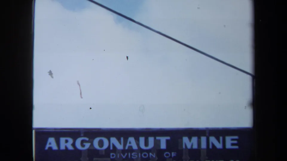 1971 Maine frame with the Argonaut Mine sign along the lower edge, pale sky above, and a diagonal utility wire crossing the view.