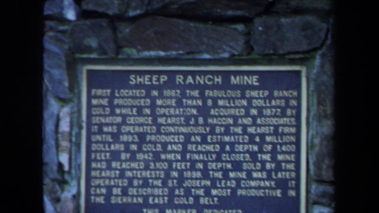 Close view of a Sheep Ranch Mine plaque mounted in a stone marker.