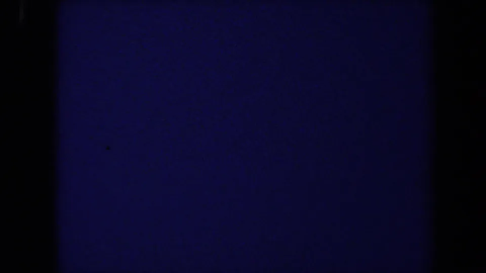 Blue-tinted 8mm transition or underexposed frame with no identifiable people, objects, or location details visible.