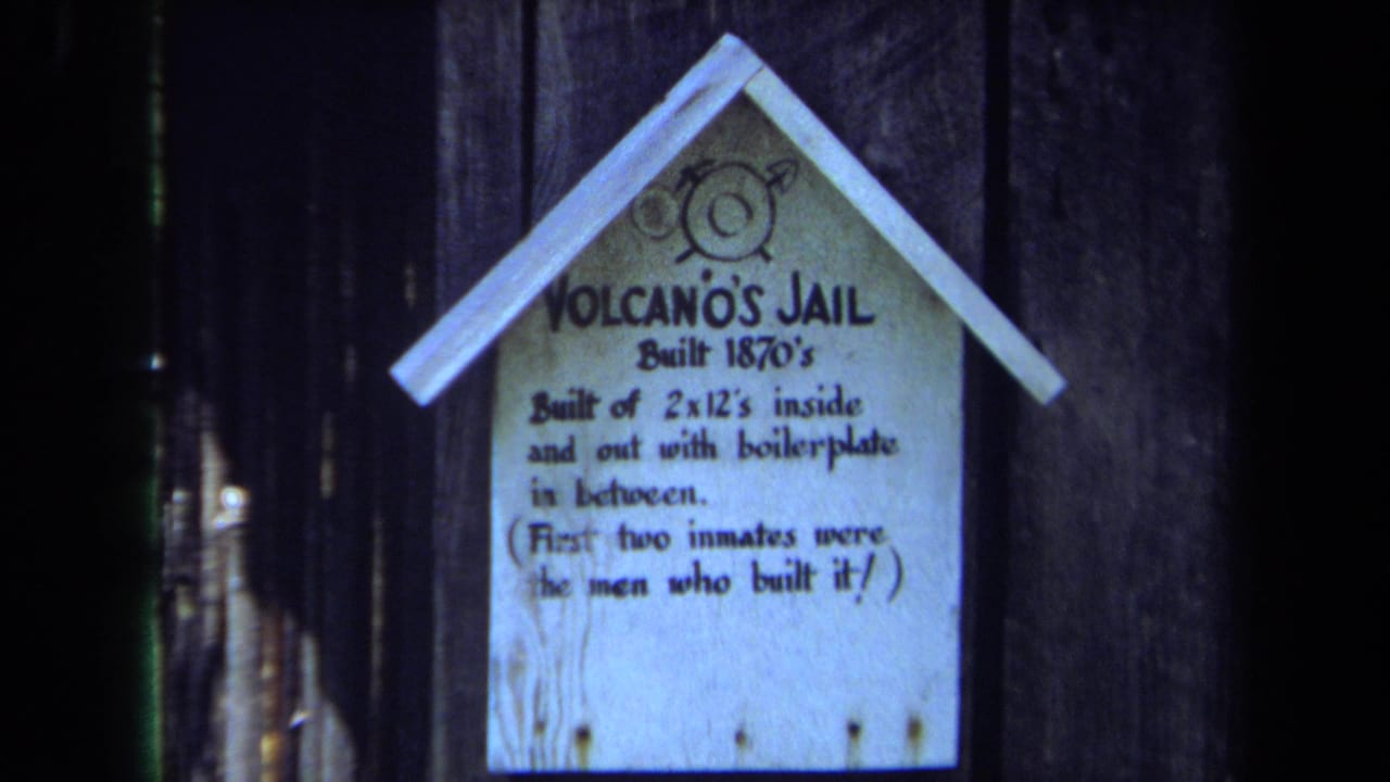 Second close view of the Volcano's Jail sign against vertical wooden boards.