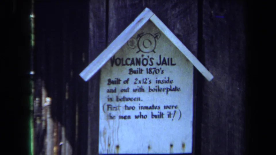 1971 Maine frame showing the sign closer and lower in view, with its handwritten jail description visible on aged wood.