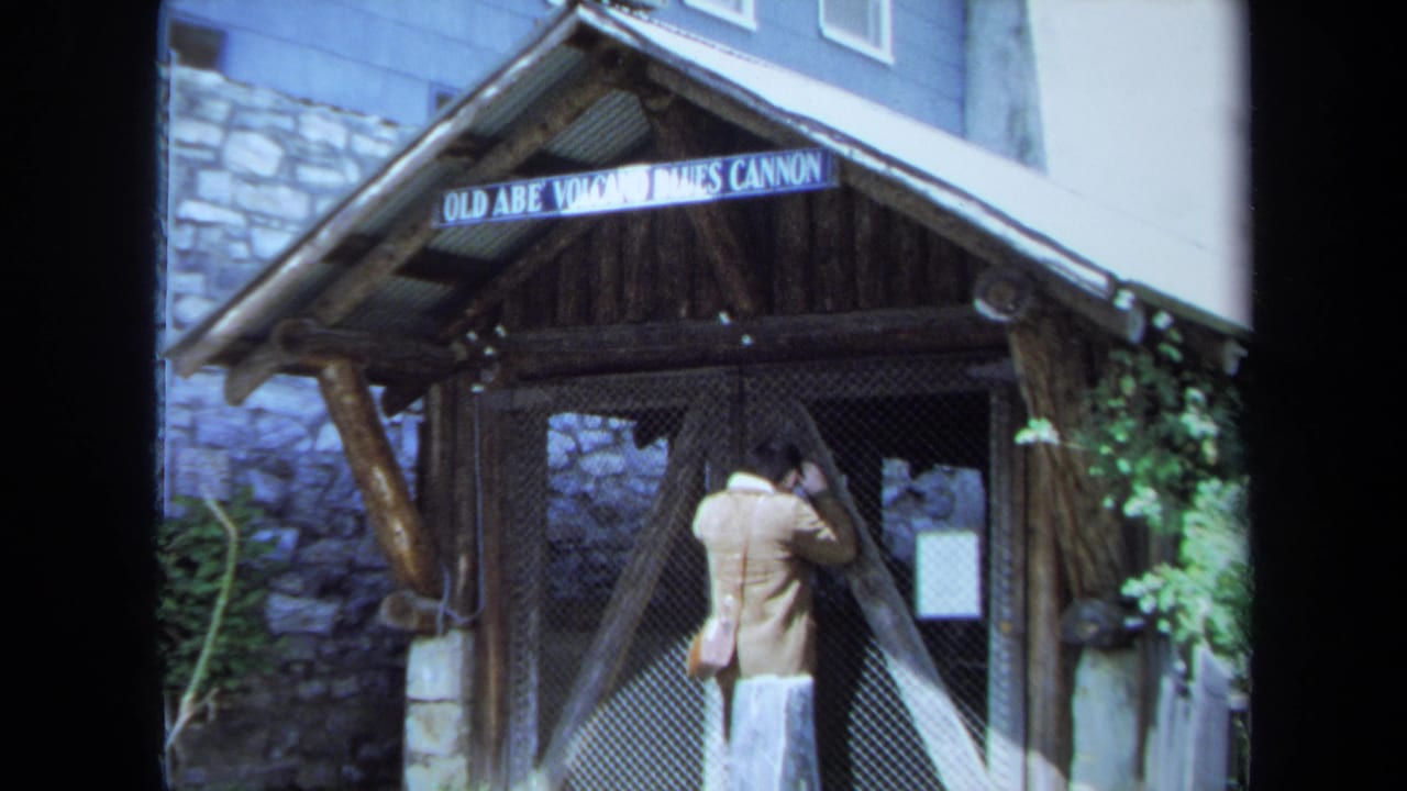 The visitor faces the gated entrance beneath the Old Abe Volcano James Cannon sign in this 1971 Maine home-movie frame.