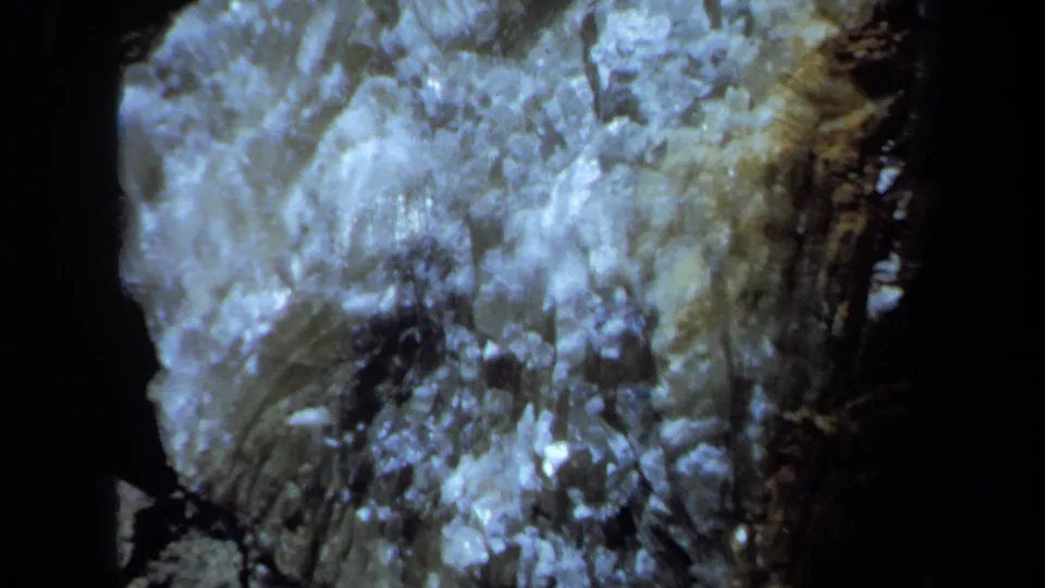 Close handheld view of a pale crystalline rock formation with shadowed edges in the 1971 Maine footage.