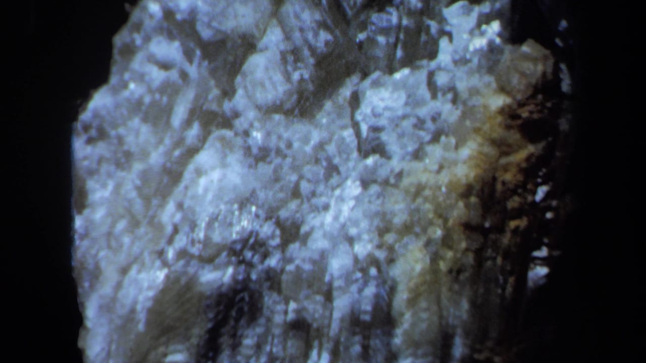 Illuminated rough mineral face with deep black shadow beside it.