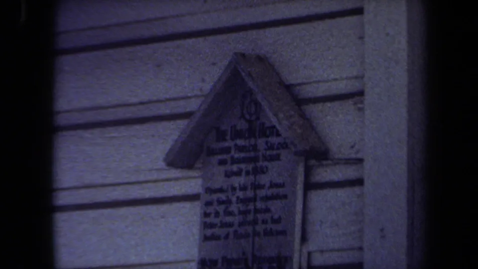 1971 Maine 8mm frame showing a closer zoom on the Union Hotel marker attached to a clapboard exterior.