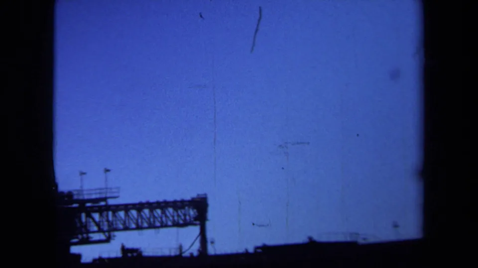 A far-off truss section and small platform railings appear in silhouette in this 1971 Maine bridge view.