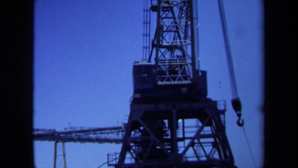 Upward 8mm view of a Maine port crane, with lattice steelwork and a hanging hook visible.