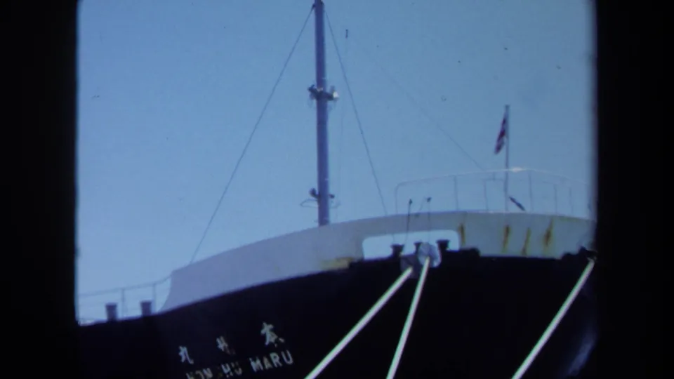 The KONSHU MARU bow appears with its mast, rail, small flag, and mooring lines in a softly framed 8mm dockside view.