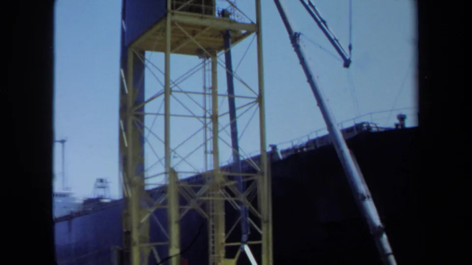 1971 Maine frame showing a yellow dock crane, diagonal rigging, and the dark hull of the docked Honshu Maru.