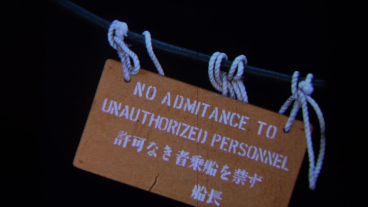 1971 Maine 8mm frame showing a rope-hung wooden sign reading no admittance for unauthorized personnel in English and Japanese.