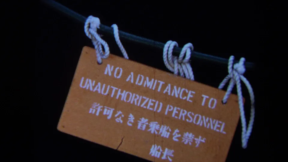 1971 Maine 8mm frame showing a rope-hung wooden sign reading no admittance for unauthorized personnel in English and Japanese.