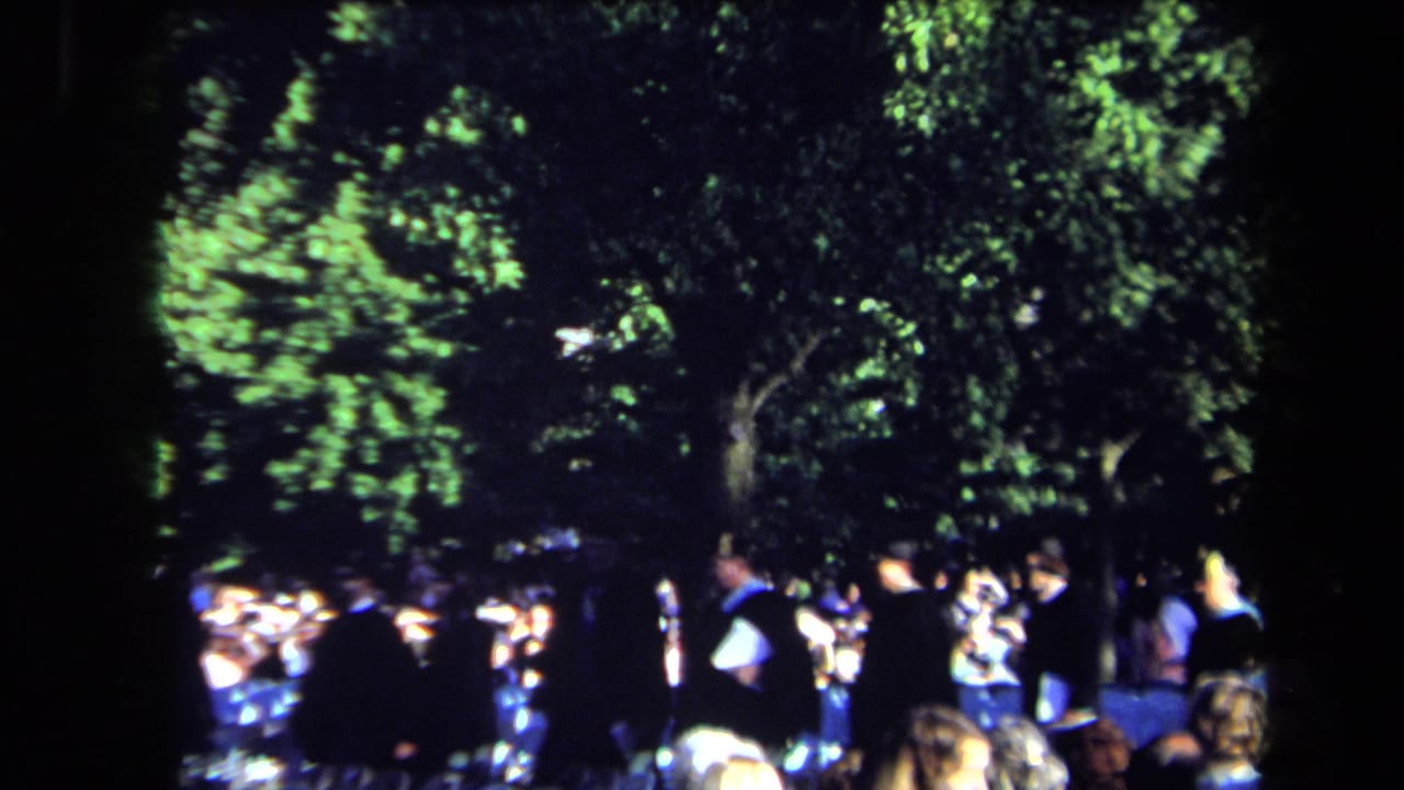 Outdoor Sacramento graduation scene from 1971 showing academic gowns, seated guests and shaded trees.