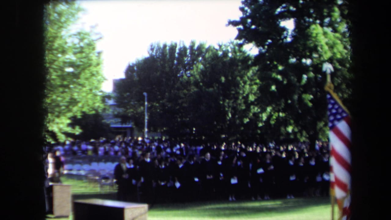 Sacramento 1971 commencement footage shows a large student assembly on grass, framed by trees and an American flag.