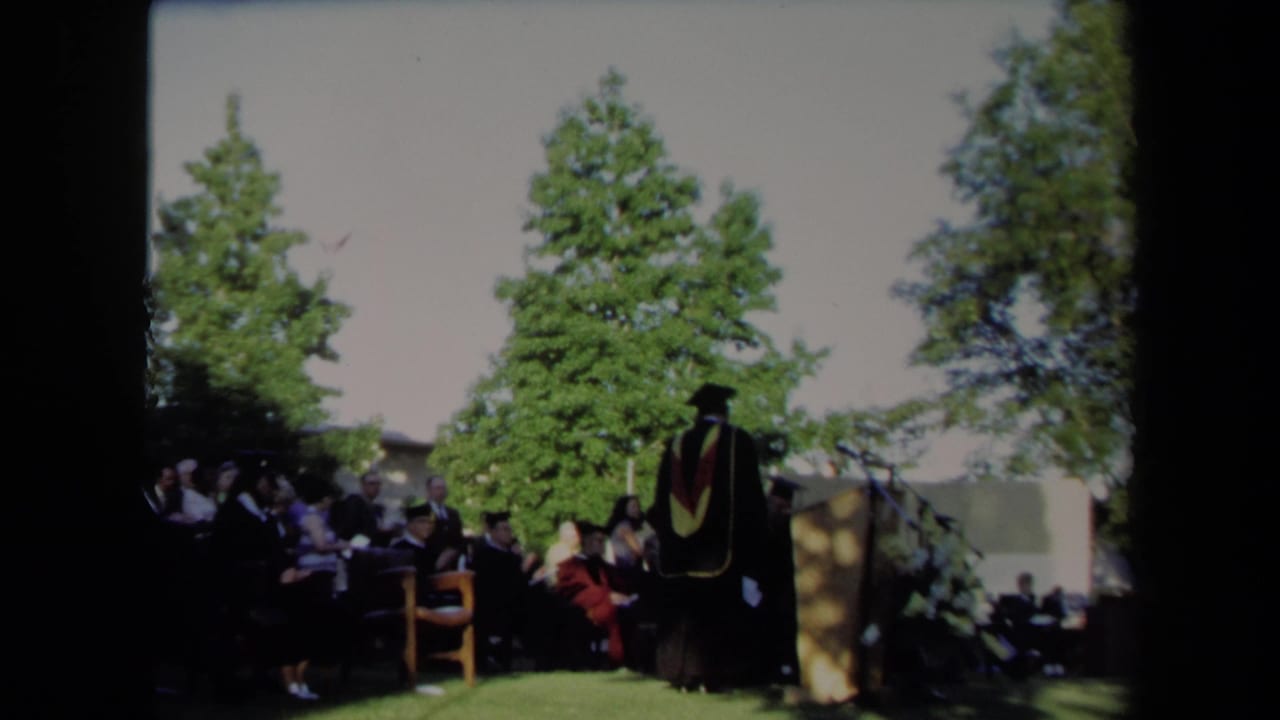 A person in academic regalia stands beside the podium during the Sacramento graduation ceremony in 1971.