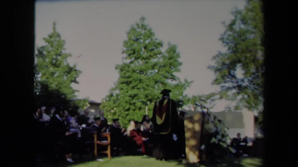 A person in academic regalia stands beside the podium during the Sacramento graduation ceremony in 1971.