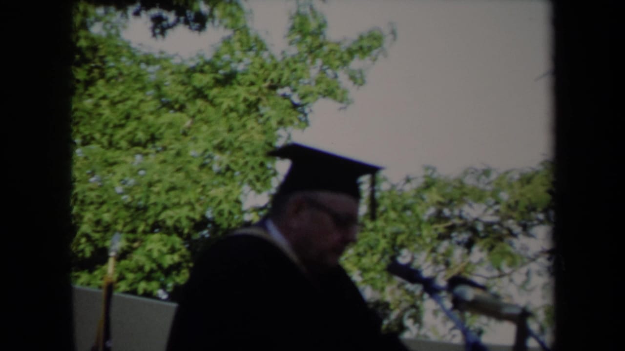A robed graduation speaker appears at a microphone outdoors in Sacramento, California, consistent with the supplied 1971 metadata.