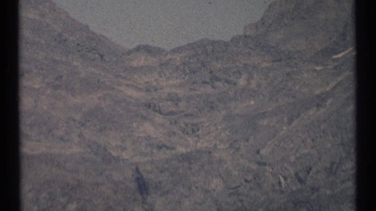 1973 8mm view of rugged mountain terrain in Scapegoat Wilderness, with muted color and no people clearly visible in this frame.