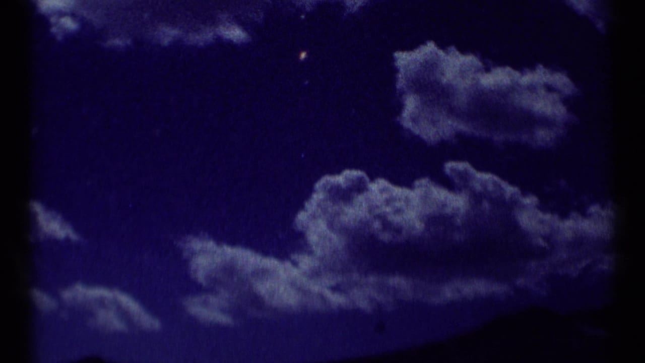 Purple-toned sky with scattered clouds and a dark mountain horizon.