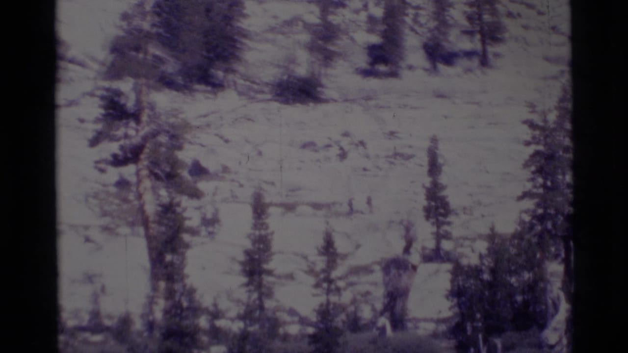 The hiking party appears as small figures moving through a rocky California wilderness landscape on vintage 8mm film.