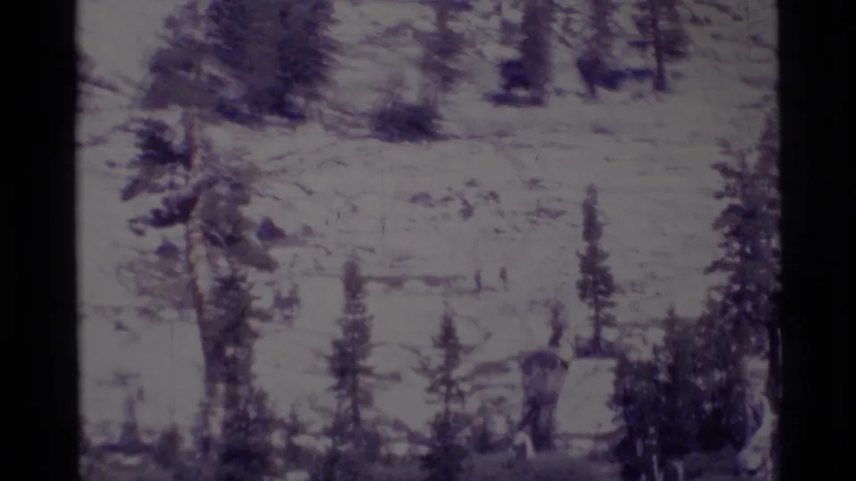 The hiking party appears as small figures moving through a rocky California wilderness landscape on vintage 8mm film.