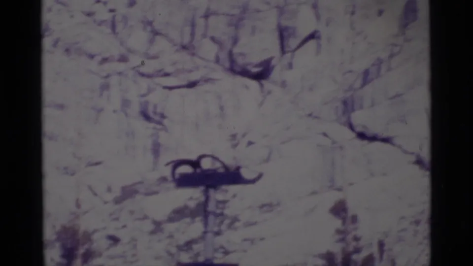 Soft 1975 8mm frame from Minaret Wilderness showing a rocky, overexposed trail or stream area with a dark object near the lower center.