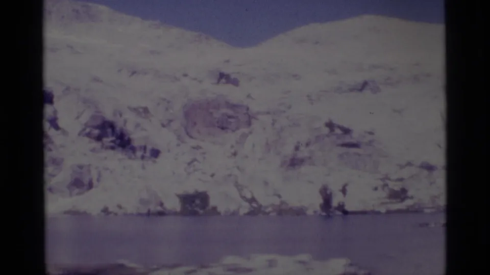 Snowy Sierra Nevada terrain and a calm lake appear in a faded 1975 home-movie frame from Minaret Wilderness.