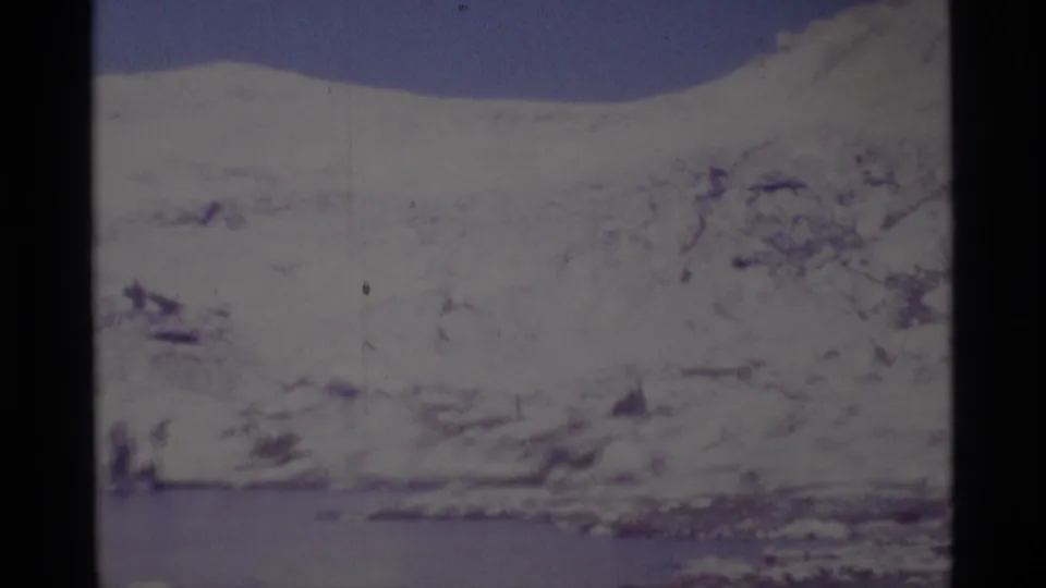 1975 8mm view of snow-covered mountains and a lake in the Minaret Wilderness, with soft focus and visible film wear.