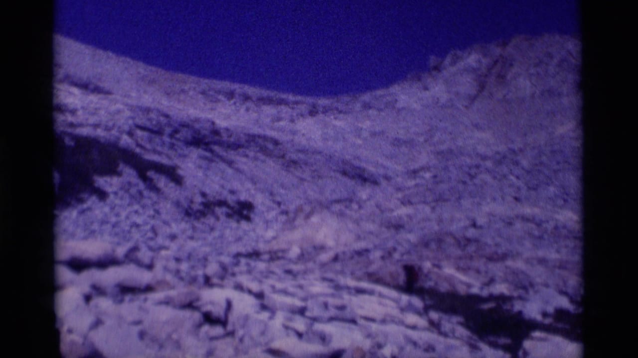 Wide 8mm view of a rugged rocky slope and pale snow patches in California's Minaret Wilderness, filmed during a 1975 hiking trip.