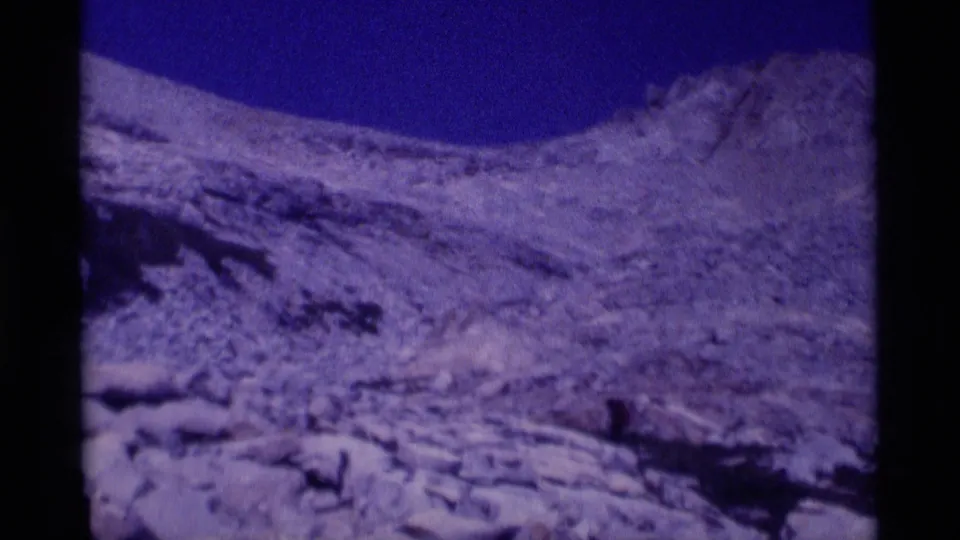 Wide 8mm view of a rugged rocky slope and pale snow patches in California's Minaret Wilderness, filmed during a 1975 hiking trip.