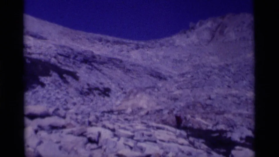 Handheld 8mm frame showing rugged alpine terrain, snow patches, and exposed rock in the Minaret Wilderness area.