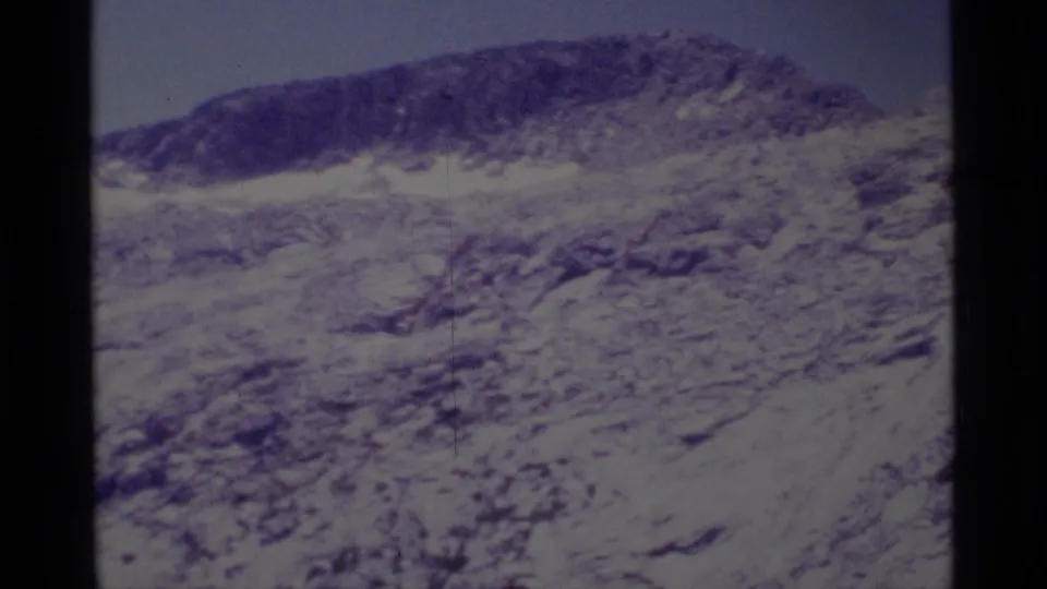 1975 8mm Minaret Wilderness view of a rocky ridge, scattered snow, and scree-like terrain with faded color.