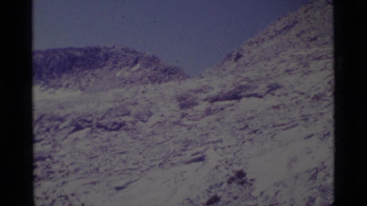Vintage 8mm view of a steep rocky ridge in the Minaret Wilderness, tinted purple-blue by aged film.