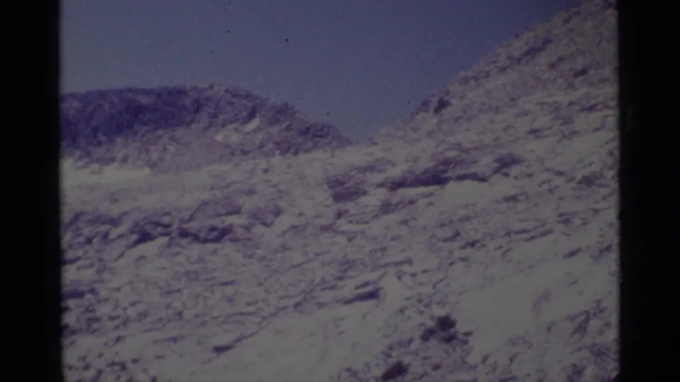 Vintage 8mm view of a steep rocky ridge in the Minaret Wilderness, tinted purple-blue by aged film.