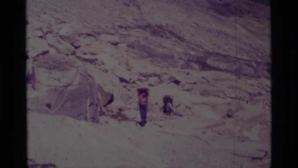 Backpackers in the Minaret Wilderness area appear on a rugged 1975 trail, framed by pale stone and open mountain terrain.