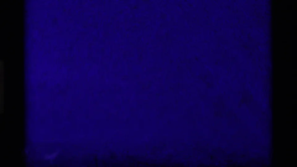 A blue-tinted 8mm transition or underexposed frame appears between mountain views, with heavy grain and dark film edges.