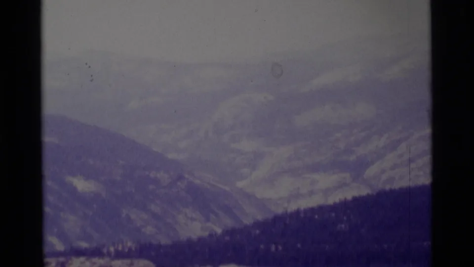 1975 California wilderness frame showing hazy mountain layers and a dark ridgeline, with no clear people in this still.