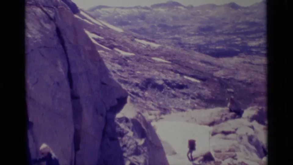 The final frame shows the rocky Minaret Wilderness slope, distant landscape, and small hikers at the edge of the 8mm home-movie frame.