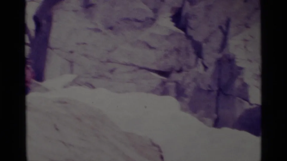 Soft 8mm view of a pale rocky alpine wall and sloping foreground in the documented Minaret Wilderness sequence.