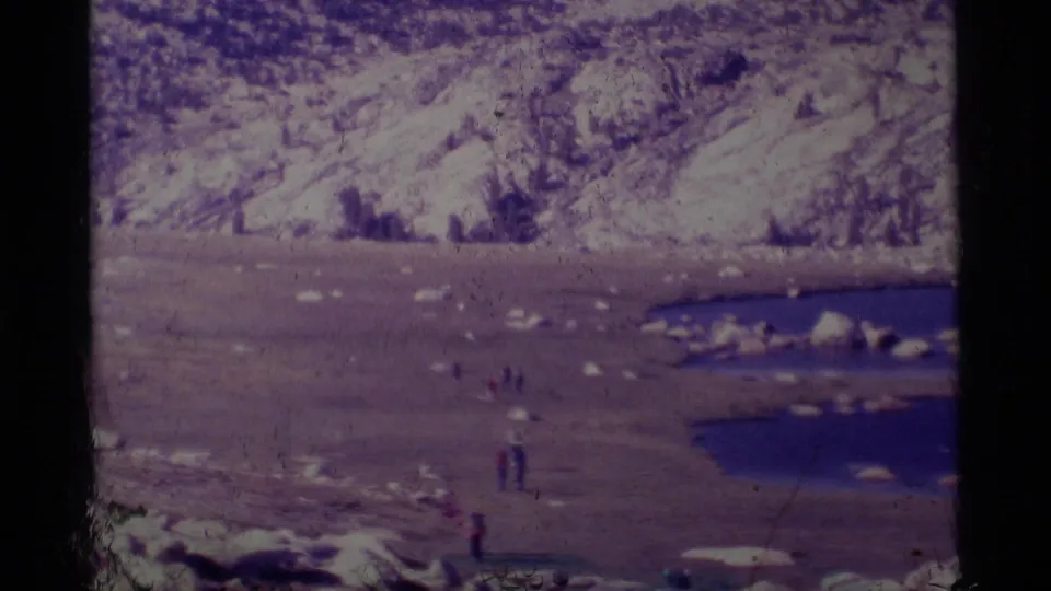 The final frame holds on distant hikers near an alpine lake below rocky Minaret Wilderness terrain in 1975 8mm film.