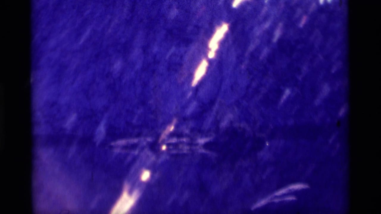 1975 Minaret Wilderness 8mm frame showing a blue-purple cave or rock interior with pale light streaks and aged film marks.