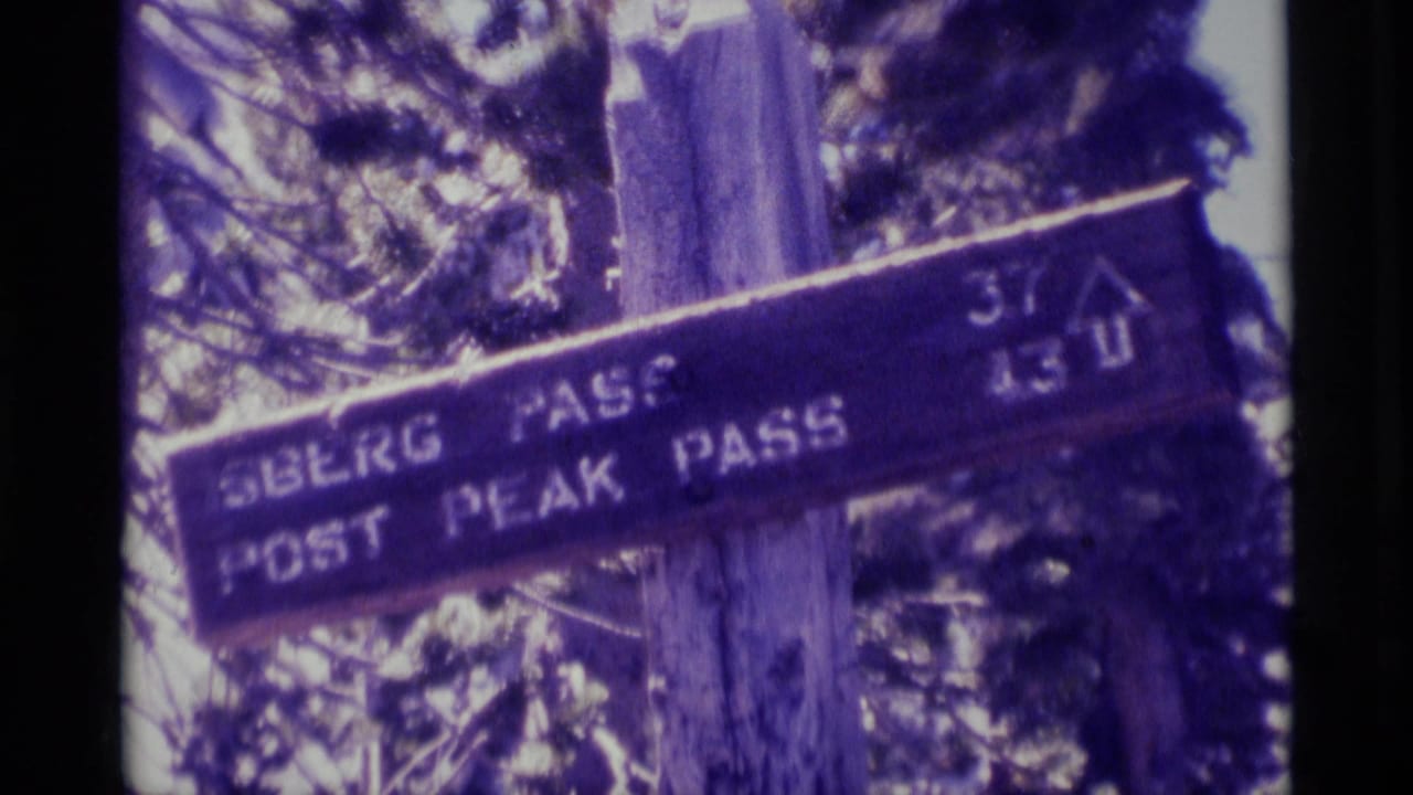 1975 Minaret Wilderness frame showing the trail sign more legibly, with pass names, elevation numbers, trees, and 8mm gate edges.