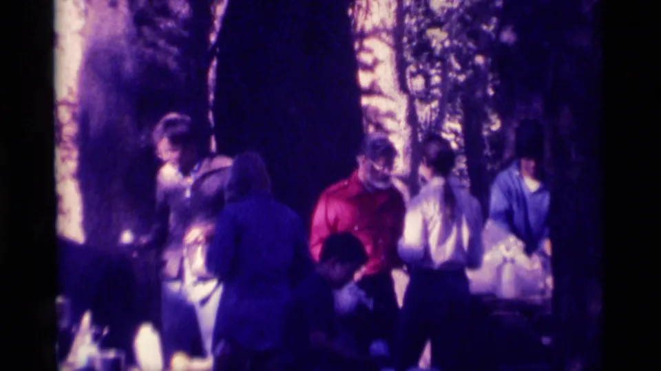 1975 8mm home-movie frame of several people gathered among trees in the Minaret Wilderness footage.