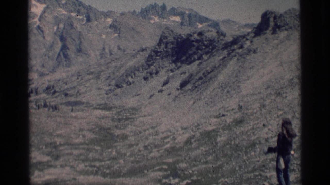 Wide 8mm view in Minaret Wilderness with a small hiker at right and rugged alpine ridges across the frame.