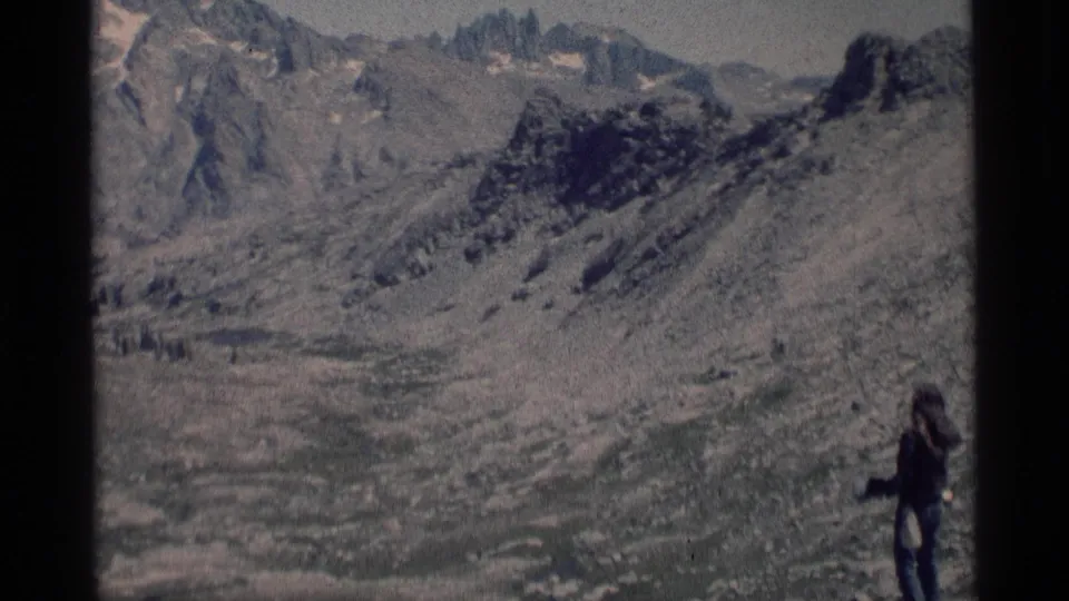 Wide 8mm view in Minaret Wilderness with a small hiker at right and rugged alpine ridges across the frame.