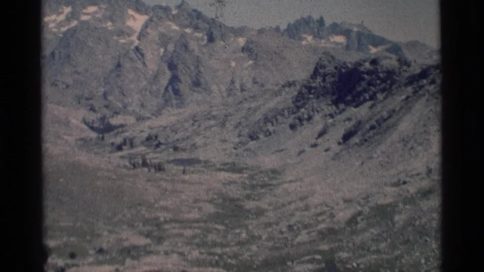 1975 8mm landscape view of the Minaret Wilderness, with rocky slopes and jagged peaks filling the frame.