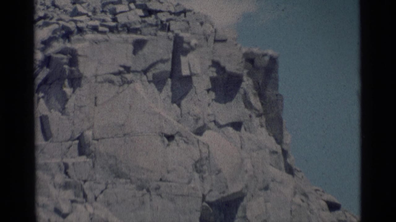 Closer view of jagged rock wall with shadowed cracks.