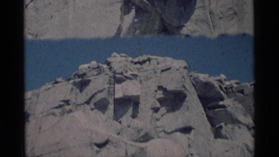 1975 home-movie frame showing a close, steady view of broken pale rock in the California wilderness.